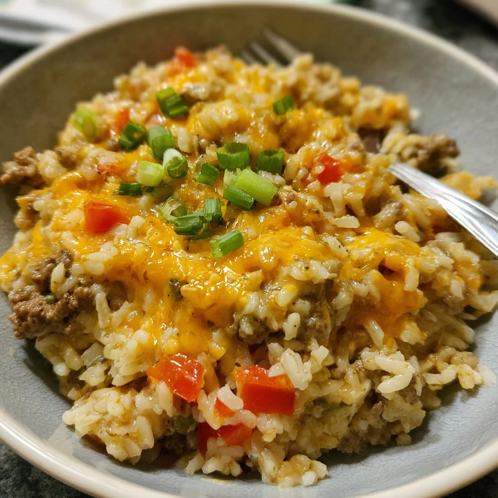 Cheesy hamburger rice casserole in a baking dish with melted cheese on top