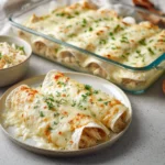 Delicious creamy white chicken enchiladas garnished with cilantro and served on a plate.