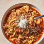 High protein lasagna soup in a bowl with fresh herbs on top