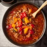High protein stuffed pepper soup in a bowl with fresh ingredients.
