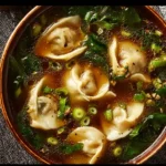 Bowl of delicious potsticker soup with dumplings and vegetables.