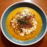 Bowl of spicy butternut squash soup garnished with herbs