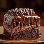 A delicious slice of German Chocolate Poke Cake topped with coconut-pecan frosting.