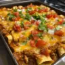 Delicious beef enchilada casserole topped with cheese and garnished with cilantro.