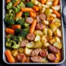 Sheet pan dinner featuring chicken apple sausage with vegetables.