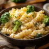 Creamy broccoli pasta dish in a bowl, topped with grated cheese.