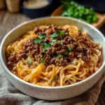 Easy Mongolian ground beef noodles served in a bowl with fresh vegetables.