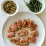 Homemade ground turkey breakfast sausages on a plate with herbs and spices