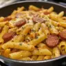 Delicious One Pot Kielbasa Pasta served in a bowl with fresh herbs and ingredients.