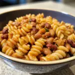 A delicious plate of pasta and beans garnished with herbs.