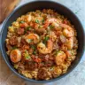 Delicious Shrimp and Sausage Jambalaya served in a bowl with fresh herbs