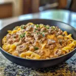 Easy 30-minute ground beef stroganoff served with pasta and garnished with parsley.