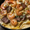 Cajun shrimp steak alfredo pasta served in a creamy sauce with herbs
