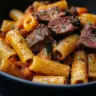 Delicious Cowboy Butter Steak Pasta served in a bowl with fresh herbs.