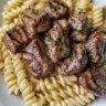 Creamy garlic butter steak bites served with spicy Cajun Alfredo pasta.