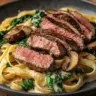 Creamy garlic pasta with sirloin and spinach served in a bowl