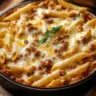 Creamy Rotel pasta with ground beef in a bowl, garnished with herbs.