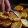 Plate of crispy oven roasted potatoes garnished with herbs