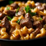 Decadent creamy steak pasta dish garnished with herbs