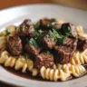Plate of Garlic Butter Steak Bites served with creamy shell pasta