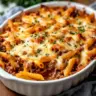 Baked Ground Beef Casserole topped with cheese and herbs ready to serve.