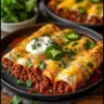 Delicious ground beef enchiladas topped with cheese and garnished with cilantro.