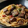 Sweet and Spicy Garlic Steak Pasta dish with vibrant colors and garnished herbs