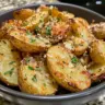 Air fryer baked garlic parmesan potatoes on a plate garnished with herbs