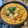 Bowl of Cajun Potato Soup garnished with green onions and spices