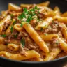 A delicious plate of creamy beef pasta garnished with herbs.