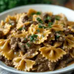 Creamy beef pasta dish garnished with herbs in a bowl