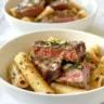 Creamy garlic butter steak rigatoni topped with parsley and Parmesan cheese