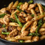 Creamy mushroom and asparagus chicken penne dish served in a bowl