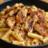 Creamy rotisserie chicken pasta served in a bowl with herbs and parmesan cheese