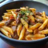 Creamy White Cheddar Cajun Steak Penne with spices and steak garnished