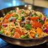 Crunchy ramen salad with vegetables and dressing on a white plate