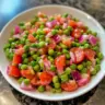 Bowl of easy English Pea Salad with fresh vegetables and dressing