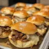 Easy Philly Cheesesteak Sliders with melted cheese and sautéed peppers on a platter.