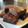 Flourless Greek Yogurt Brownies served on a plate with chocolate drizzles