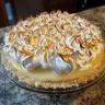Fluffy no bake lemon meringue pie topped with golden meringue and lemon zest.