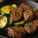 Garlic butter steak bites served in a skillet with fresh herbs.