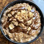 Bowl of high-protein peanut butter overnight oats topped with fruits and nuts