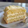 Slice of Italian Lemon Cream Cake with lemon zest and cream topping