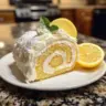 Delicious Lemon Cake Roll served on a plate with fresh lemon slices.