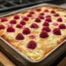 Lemon Raspberry Cottage Cheese Bake topped with fresh raspberries and lemon slices