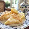 Freshly baked lemon scones on a plate with a lemon slice