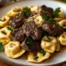 One-pan dish of steak bites and cheesy tortellini served on a plate