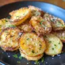 Delicious Parmesan Smashed Potatoes served on a plate with herbs