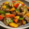 Pepper steak with bell peppers and onions served on a plate