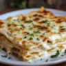 Delicious creamy white lasagna served in a dish with herbs on top